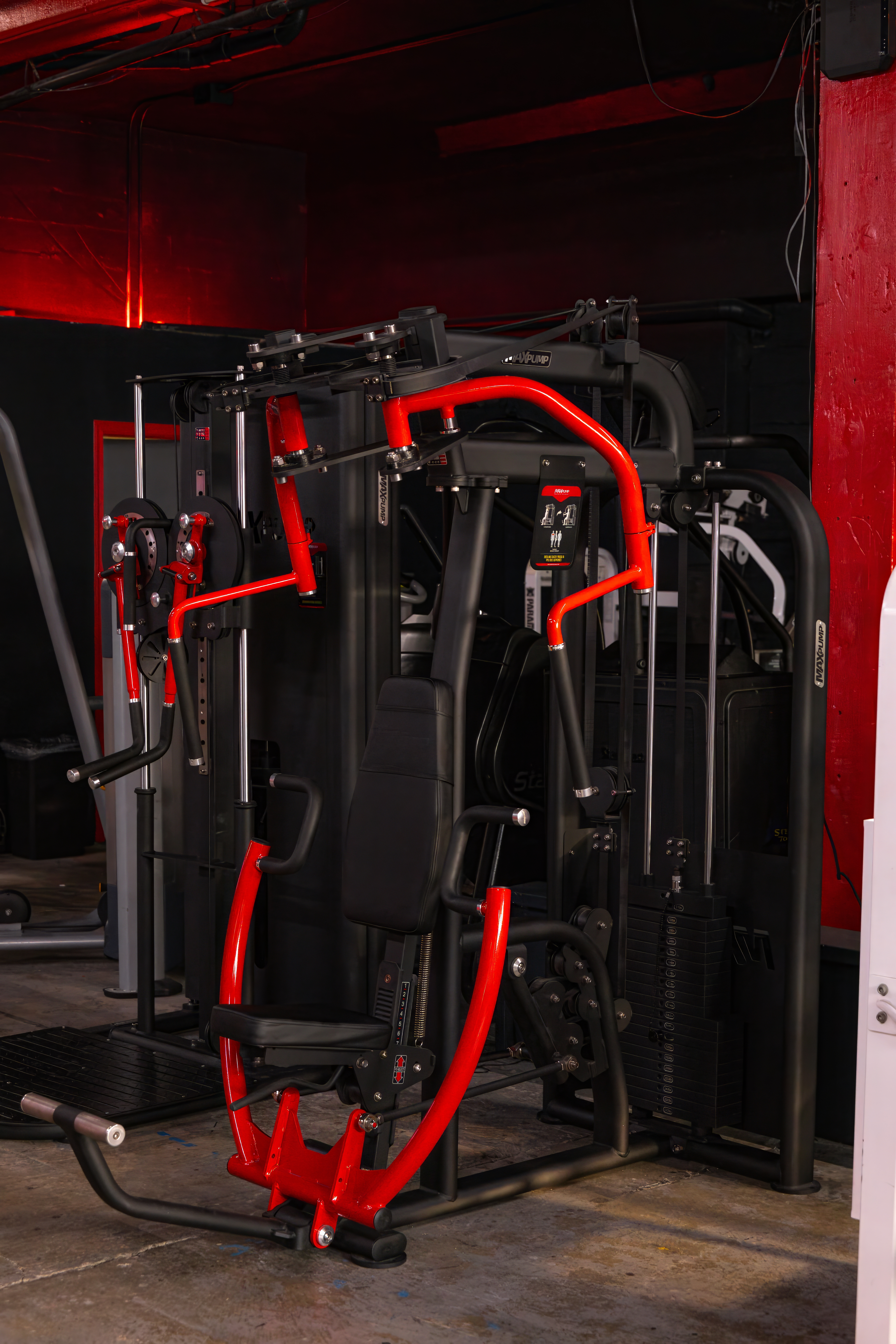 Close-up of a selectorized chest press machine with a striking red frame, showcasing the variety of high-quality, modern strength equipment